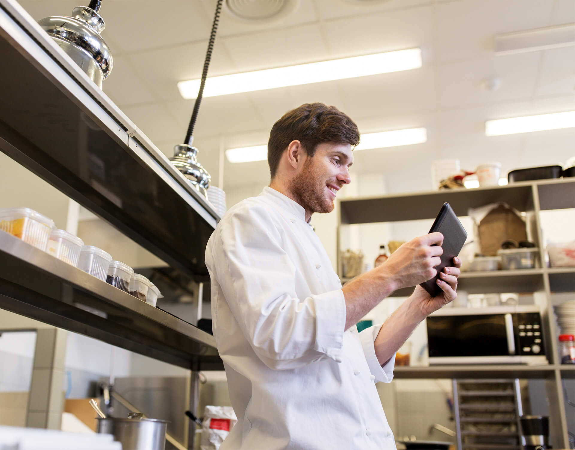 Chef using a tablet in a working kitchen